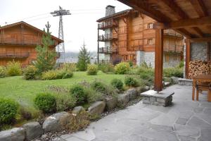 a patio in front of a house with a garden at Eclat de Soleil 023 in Verbier