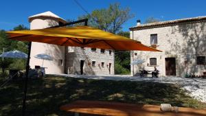 a large yellow umbrella in front of a building at Dimora Barbolani in Lettopalena