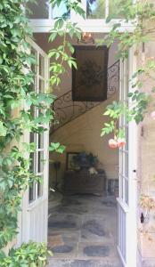 an entrance to a house with an open door at L'Orangerie du Grand Jardin in Condé-sur-Seulles