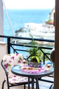 a table with a potted plant on a balcony at Sea View Apartments 10meters from the beach in Agia Pelagia