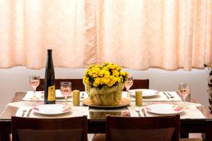 a table with a vase of flowers and a bottle of wine at Sea View Apartments 10meters from the beach in Agia Pelagia