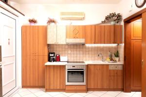 a kitchen with wooden cabinets and a stove top oven at Sea View Apartments 10meters from the beach in Agia Pelagia