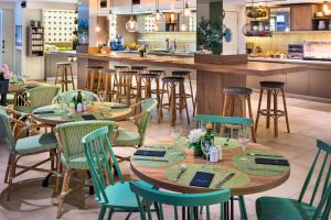 un restaurante con mesas y sillas y un bar en Catalonia Santa Justa, en Sevilla