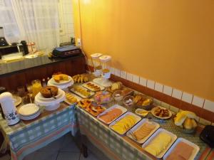 Un buffet con muchos tipos diferentes de comida en una mesa. en Pousada Cavaleiros, en Macaé