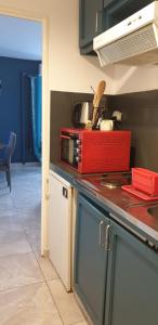 una cocina con un aparato rojo en una encimera en T1 tout confort 2, en Sainte-Clotilde