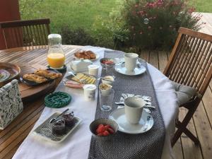 a table with breakfast foods and coffee and orange juice at Maison Fleurie in Uhart-Cize