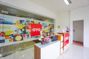 a lobby with a store with an omo sign and flowers at OYO 1838 COZY Home in Manado