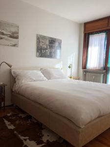 a bedroom with a large bed with white sheets at Clotes in Sauze dʼOulx