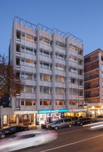 an office building with cars parked in front of it at Hotel Tunali in Ankara