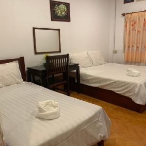 um quarto com 2 camas, uma cadeira e um espelho em Dalom Guesthouse em Don Det