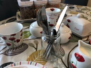 a table with utensils in a vase on a table at Lyndon B&B in Birmingham +70 photos
