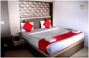a bedroom with a large bed with red pillows at Peace Residency in Pondicherry