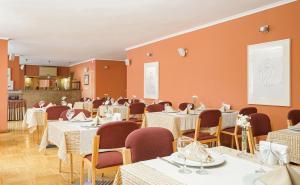 a dining room with tables and chairs and a screen at Hotel Tunali in Ankara