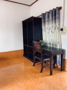 a table and a chair in a room at Dalom Guesthouse in Don Det