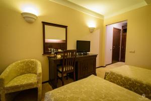 ein Hotelzimmer mit einem Schreibtisch mit einem Stuhl und einem Spiegel in der Unterkunft Apartament Alpin resort etaj 7 in Poiana Brașov + 25 Fotos