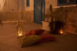 due cuscini sul pavimento con una lanterna e una pianta di Torre Chianca GMA Tourism a Porto Cesareo