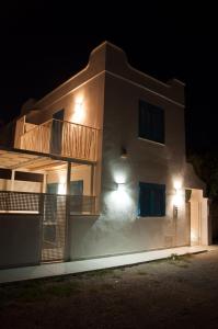 una casa bianca con balcone di notte di Torre Chianca GMA Tourism a Porto Cesareo