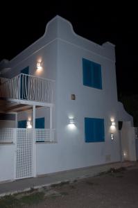 un edificio bianco con finestre blu di notte di Torre Chianca GMA Tourism a Porto Cesareo