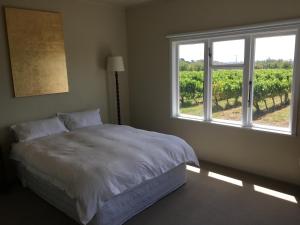 Ένα ή περισσότερα κρεβάτια σε δωμάτιο στο Tuki Vineyard Cottage