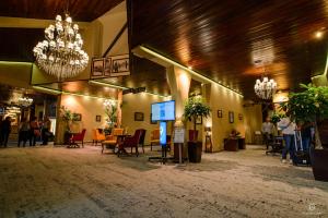 eine Lobby mit einem Tisch, Stühlen und einem Kronleuchter in der Unterkunft Apartament Alpin resort etaj 7 in Poiana Brașov