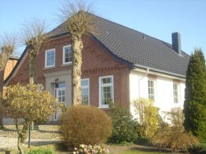 una casa con un árbol en el patio delantero en Landhaus Kopendorf, en Bojendorf