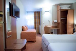 Un pat sau paturi într-o cameră la Kyriad Rennes Nord Hotel