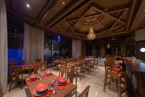a dining room with tables and chairs and a chandelier at Hôtel Ibn Batouta in Marrakesh