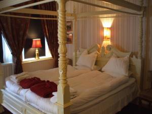 a large white bed in a bedroom with two lamps at Nygårds Herrgård Bed & Breakfast in Mönsterås