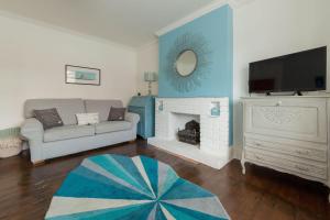 a living room with a couch and a fireplace at Sea Glimpses with garden, beachhut, parking in Broadstairs