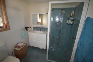 a bathroom with a shower and a sink at Seascape Beach House in Boat Harbour +30 photos