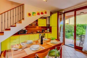 une cuisine avec des armoires jaunes et une table en bois dans l'établissement Casa Delisa, à Manerba del Garda