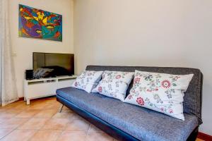 a living room with a couch with pillows and a tv at Casa Delisa in Manerba del Garda