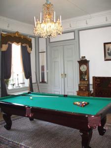 a living room with a pool table and a chandelier at Nygårds Herrgård Bed & Breakfast in Mönsterås