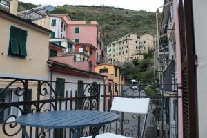 una mesa y sillas en un balcón con edificios en CAMERA GIGLIA en Manarola