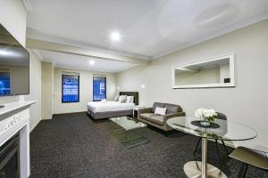 ein Wohnzimmer mit einem Bett und einem Sofa in der Unterkunft Aloha Central Premium Studios in Mount Gambier