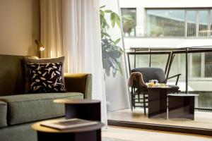 a living room with a couch and a chair and a table at Wilde Aparthotels Berlin, Checkpoint Charlie in Berlin