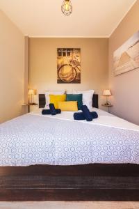 - une chambre avec un grand lit blanc et des oreillers colorés dans l'établissement Appartement de charme, spacieux, Moustiers #5, à Moustiers-Sainte-Marie