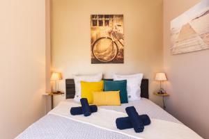 a bedroom with a bed with yellow and green pillows at Appartement de charme, spacieux, Moustiers #5 in Moustiers-Sainte-Marie