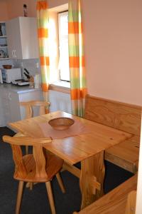 a wooden table and chairs in a kitchen at Penzion U mlýna in Rejvíz