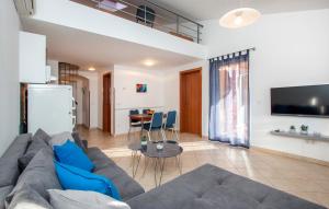 ein Wohnzimmer mit einer grauen Couch und einem Tisch in der Unterkunft Oliva Holiday Apartment in Banjole