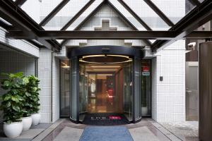 una entrada a un edificio con una puerta de cristal en the b suidobashi, en Tokio