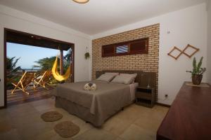 a bedroom with a bed and a brick wall at BEACH HOUSE Barra Grande - CASA INTEIRA - WHOLE HOUSE in Barra Grande
