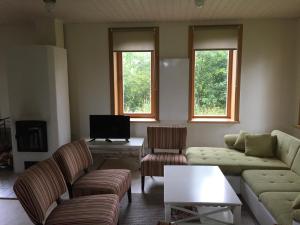 a living room with two couches and a tv at Mokko Lakehouse in Kuremaa