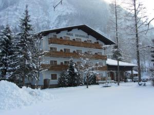 a hotel in the snow with a mountain in the background at Haus Brunhilde in Fusch an der Glocknerstraße