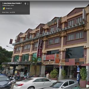 a large building with cars parked in front of it at Hotel Orient in Johor Bahru