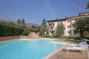 een zwembad met 2 stoelen en een gebouw bij Il Cedro in Salò