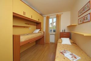 een kleine slaapkamer met twee bedden en een raam bij Il Cedro in Salò +19 foto's