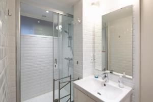 een badkamer met een douche, een wastafel en een spiegel bij 2 Montfort in Rennes