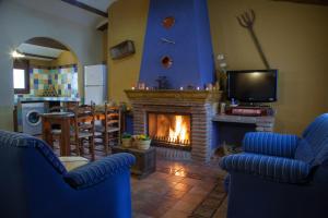 a living room with a fireplace and a tv at Apartamentos La Granja in Hinojares