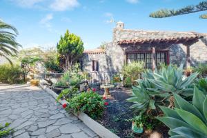 un jardín frente a una casa de piedra en Estudio Cardón, en Arona